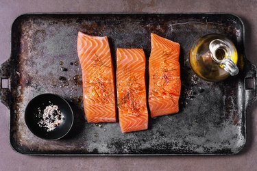 Fresh salmon on a pan next to olive oil