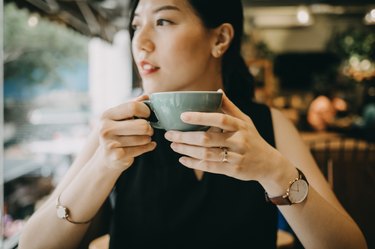 Young woman enjoying tea thinking about pro and cons of green tea