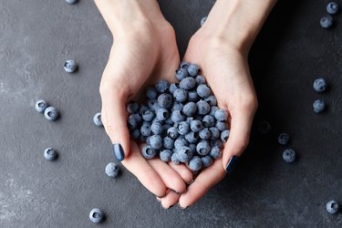 Close up of woman hands holding fresh blueberries