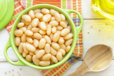 Potassium-rich lima beans in green pot on table with colorful orange placemat