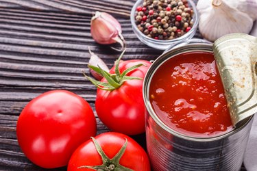 juicy canned tomatoes on wooden rustic background