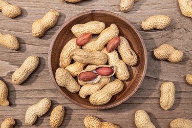 Peanuts in bowl on rustic wooden table