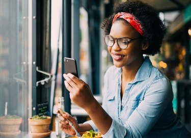 A woman wearing glasses and eating a lunch with foods good for eye health