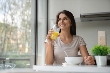 Happy woman having breakfast at home