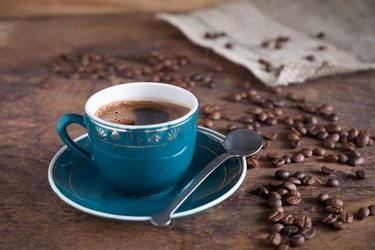 Coffee cup and roasted beans on a wooden background