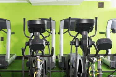 Row of treadmills and ellipticals in a gym for weight loss