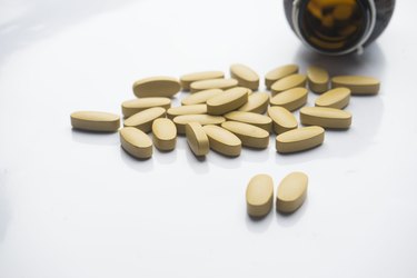 levothyroxine tablets and a glass pill bottle on a white counter