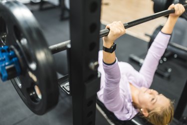 Young woman exercising on the bench press