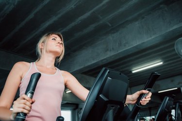Portrait of sporty woman exercising elliptical in fitness gym., Group of pretty women in sportswear working out cardio training at gym.,Wellness program and sport healthy concept.