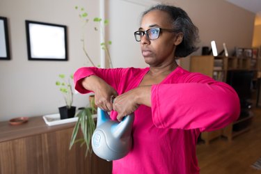 Woman strength training at home with kettlebell