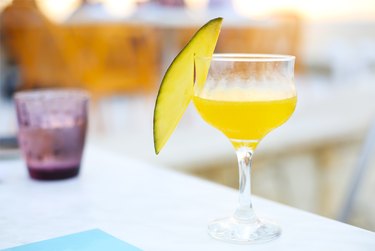 Glass of mango cocktail on bar counter