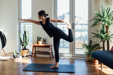 Young woman doing yoga exercise at home, as a restless legs syndrome treatment
