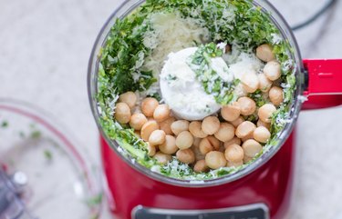 Making pesto in the food processor with macadamia nuts.