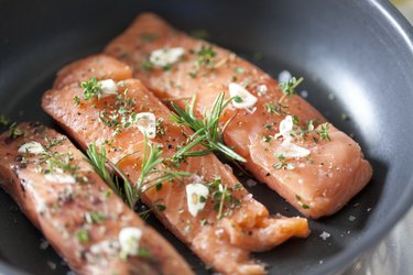 Delicious salmon fillet in a pan with garlic and herbs