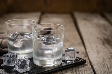 Vodka in shot glasses on rustic wood background