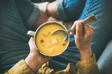 Woman eating fall vegetables in soup recipes