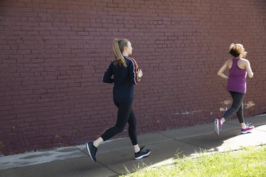 女性在城市人行道上奔跑