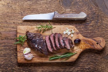 slices of a grilled steak on wood