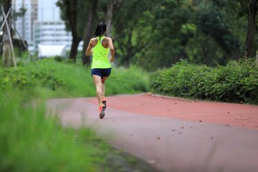 Person running at an outdoors jogging track in park