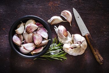 Garlic bulb and cloves shot from above on rustic brown background