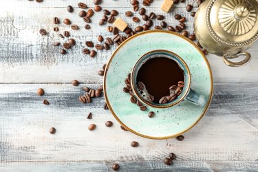 Composition with cup of hot coffee on wooden table