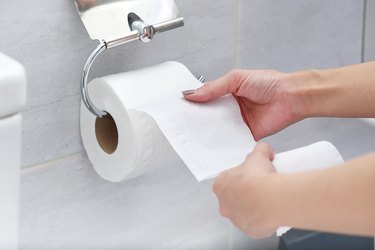 Midsection Of Person Holding Tissue Paper In Bathroom