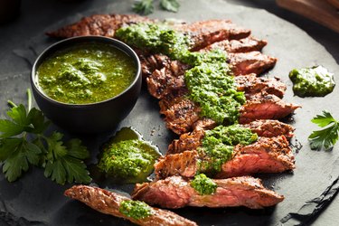 Tyrosine-rich cooked skirt steak with chimichurri on a black platter