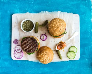 Fresh beef burger with cheese, vegetables, spicy tomato sauce on