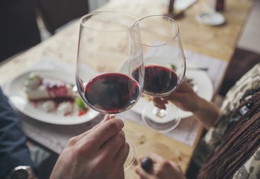 Couple toasting with red wine in cafe