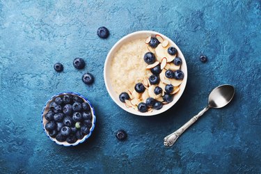 碗啊atmeal porridge with banana and blueberry on vintage table top view in flat lay style. Homemade breakfast.