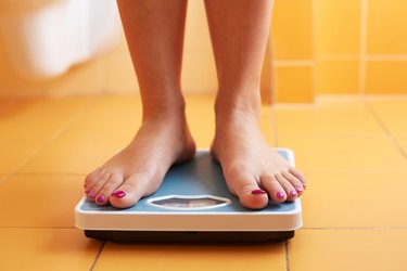 Pair of female feet on a bathroom scale