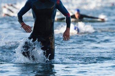 Triathletes running out of the water on triathlon