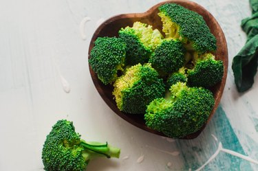 Chopped broccoli on a wooden heart-shaped bowl