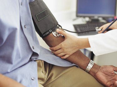 Female doctor taking patient's blood pressure