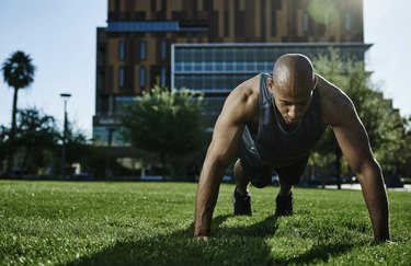 athlete doing a push-up in a park