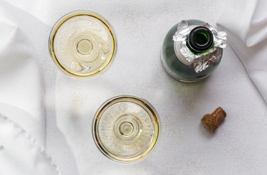 Directly Above Shot Of Champagne Flutes By Bottle On Table