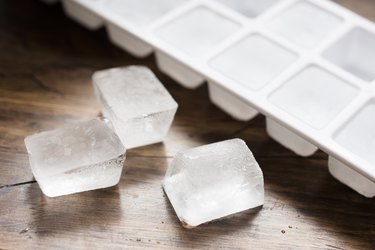 Ice cubes on a wooden table, as a cold sore remedy