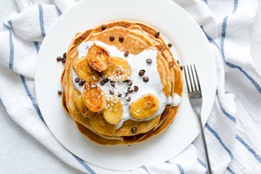 Pancakes with caramelized bananas table top view