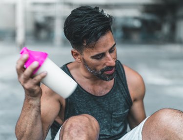 what to eat to gain muscle man mixing a Protein Shake after Exercising