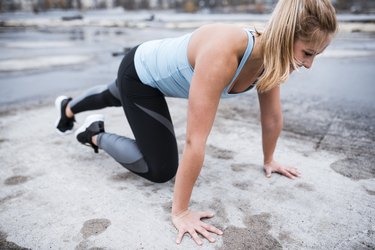 Athlete woman doing mountain climbers outdoors