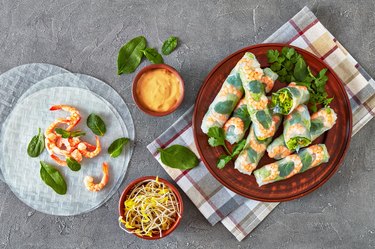 raw Asian spring rolls of rice paper with shrimps, rice noodle, lettuce and mint fillings