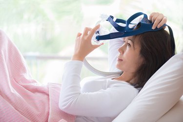 Woman lay in bed wearing CPAP mask ,sleep apnea therapy