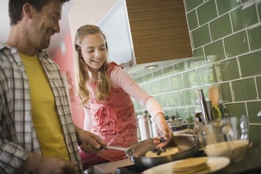 Father and daughter making pancakes