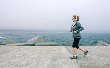 Senior sportswoman with headphones running