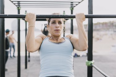 Woman Doing Pull-Ups on Monkey Bars for Fitness