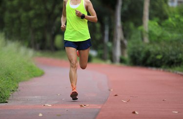 Fitness sporty woman jogger running at outdoors jogging track in park