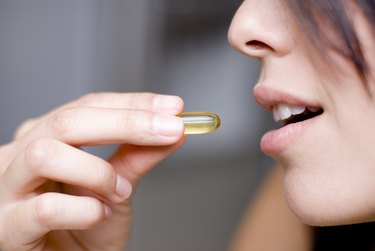 Woman taking vitamin D pill