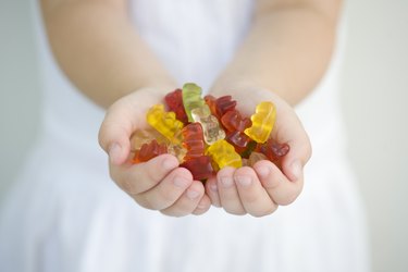 A little girl with a handful of gummy bears