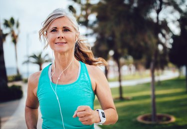 An active mature woman running in the park