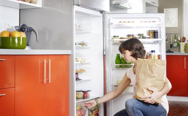 Woman learning how to organize refrigerator with fridge organization tips